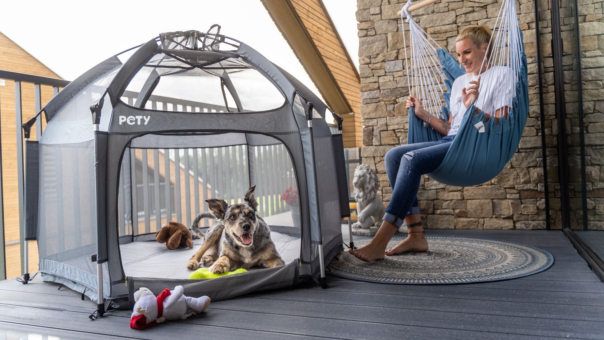 Hund im mobilen Hundelaufstall PETY auf einem Balkon